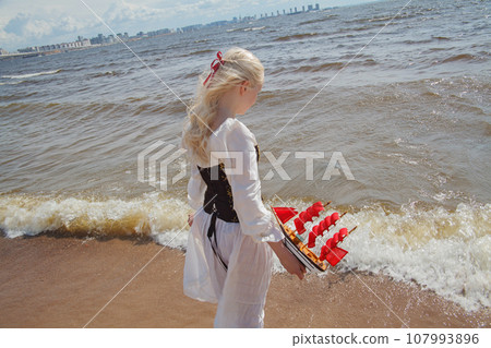 Lovely young woman walking outdoors. Beautiful lady standing on sea beach  107993896