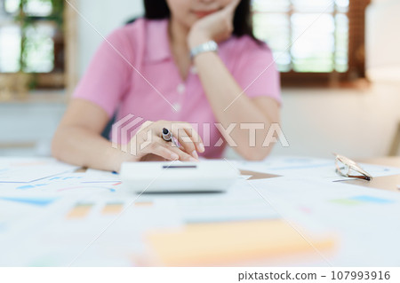 Accountants, Asian auditors are using calculators and computers to review annual tax budgets to submit information to the IRS Accountants, Asian auditors are using calculators and computers to review annual tax budgets to submit information to the IRS 107993916