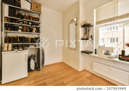 a room with some shoes and other items on the shelf in front of the window that has been used for storage 107993949
