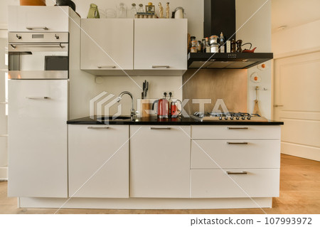 a kitchen with white cupboards and black counter tops on the counters in this room is very clean, but it's not a kitchen with white cupboards and black counter tops on the counters in this room is very clean, but it's not 107993972