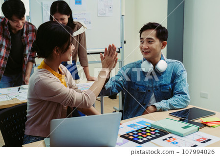 ux developers and ui designers use augmented reality to brainstorm on mobile app and web site page interface wireframe designs on modern office desks. successful, deal, success, together concepts 107994026
