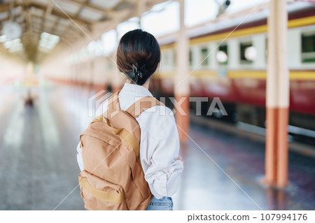 Tourists are showing happy expressions while waiting for their journey in the train station Tourists are showing happy expressions while waiting for their journey in the train station 107994176