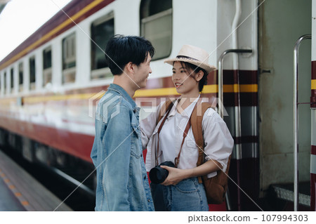 Tourist couples showing their love and happiness in a sweet way while waiting for their journey at the train station 107994303