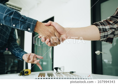 Engineers, designers and interior designers are handshake shack hands deal finalizing the design of interiors by discussing selecting materials and colors to design rooms to present to clients Engineers, designers and interior designers are handshake shack hands deal finalizing the design of interiors by discussing selecting materials and colors to design rooms to present to clients 107994343