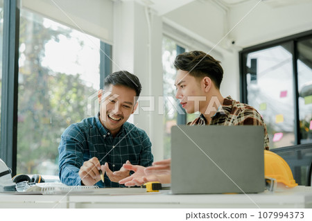 Engineers, designers and interior designers are finalizing the design of interiors by discussing selecting materials and colors to design rooms to present to clients 107994373