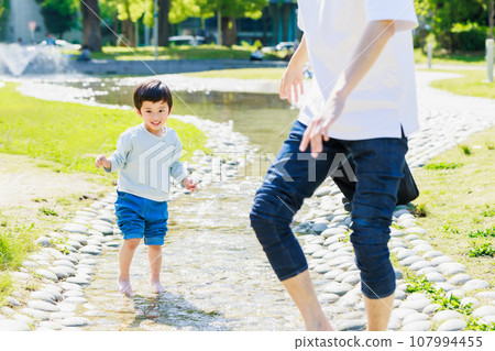 Child playing in the stream with his father Child playing in the stream with his father 107994455