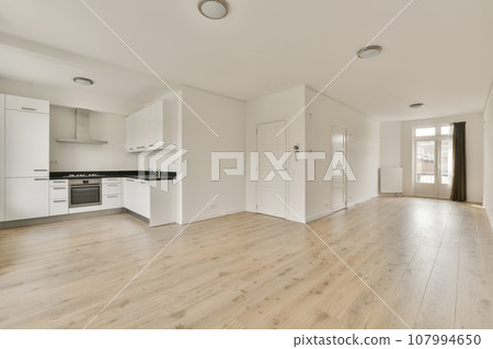 an empty living room with white walls and wood flooring the room is clean and ready for guests to use an empty living room with white walls and wood flooring the room is clean and ready for guests to use 107994650