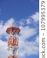 Red steel tower shining against the blue sky 107995379