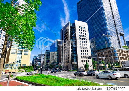 A car waiting at the traffic light heading towards the Harumi Dori intersection and Ginza. High-rise buildings and street trees in Hibiya and Yurakucho (Chiyoda Ward, Tokyo) A car waiting at the traffic light heading towards the Harumi Dori intersection and Ginza. High-rise buildings and street trees in Hibiya and Yurakucho (Chiyoda Ward, Tokyo) 107996051