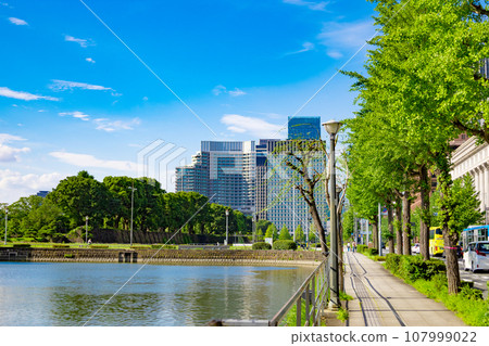 The moat of the Imperial Palace and the sidewalks and trees of Hibiya Street. High-rise buildings in Hibiya, Marunouchi, and Otemachi (Chiyoda Ward, Tokyo) 107999022