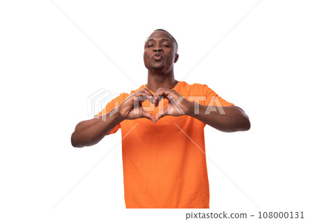 young nice kind american man dressed in an orange t-shirt on a white background with copy space 108000131