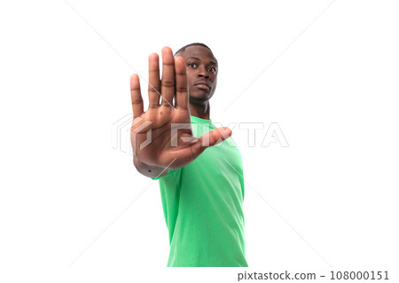 portrait of young smart african man dressed in green t-shirt and jeans isolated on white background 108000151
