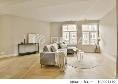 a living room with hardwood flooring and white walls in the center of the room is a large window that looks out onto the 108001339