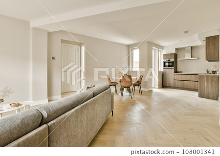 a living room with wood flooring and white walls in an apartment, taken from the front view to the dining area a living room with wood flooring and white walls in an apartment, taken from the front view to the dining area 108001341