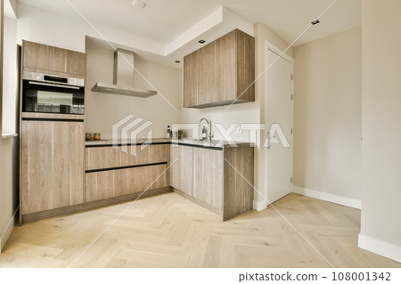 a modern kitchen with wood flooring and white walls in the room is very clean, ready for guests to use a modern kitchen with wood flooring and white walls in the room is very clean, ready for guests to use 108001342