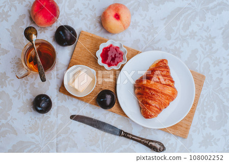 Croissant with tea, jam and fruits for breakfast Croissant with tea, jam and fruits for breakfast 108002252