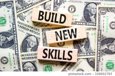 Build new skills symbol. Concept word Build new skills on beautiful wooden block. Dollar bills. Beautiful dollar bills background. Business, education build new skills concept. Copy space. Build new skills symbol. Concept word Build new skills on beautiful wooden block. Dollar bills. Beautiful dollar bills background. Business, education build new skills concept. Copy space. 108002765