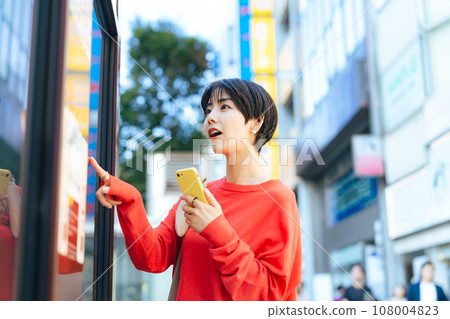 一個女人拿著智慧型手機,看著地圖 一個女人拿著智慧型手機,看著地圖 108004823