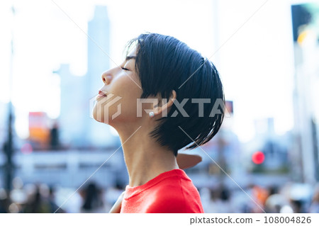 A woman looking up at the sky in the city A woman looking up at the sky in the city 108004826