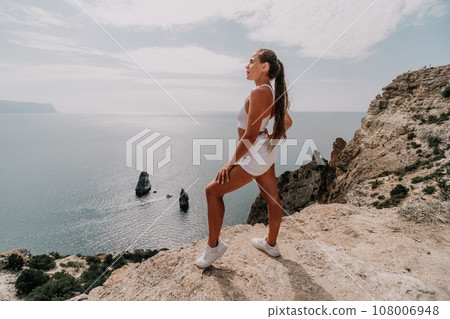 Woman travel sea. Young Happy woman posing on a beach over the sea on background of volcanic rocks, like in Iceland, sharing travel adventure journey Woman travel sea. Young Happy woman posing on a beach over the sea on background of volcanic rocks, like in Iceland, sharing travel adventure journey 108006948