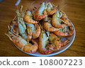 The Whole grill big shrimps with salt and pepper on blue fabric background from above. Fresh cooked delicious grilled shrimps served on plate top view, healthy seafood meal 108007223