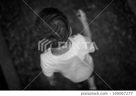 Above view of a Caucasian boy going hiking with a walking stick Above view of a Caucasian boy going hiking with a walking stick 108007277