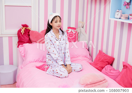 年輕女子在色彩繽紛的臥室裡放鬆 108007903