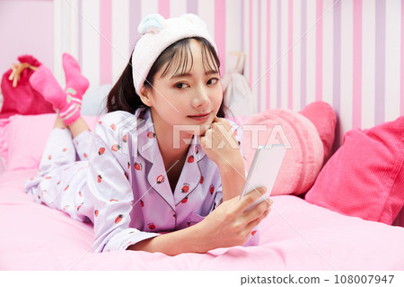 Young woman relaxing in colorful bedroom 108007947