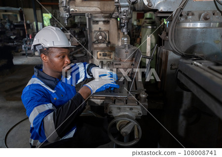 Male African American workers wearing uniform safety and hardhat using laptop working at machine Male African American workers wearing uniform safety and hardhat using laptop working at machine 108008741