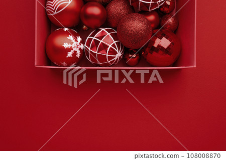Red Christmas baubles decoration in the box on red background Red Christmas baubles decoration in the box on red background 108008870