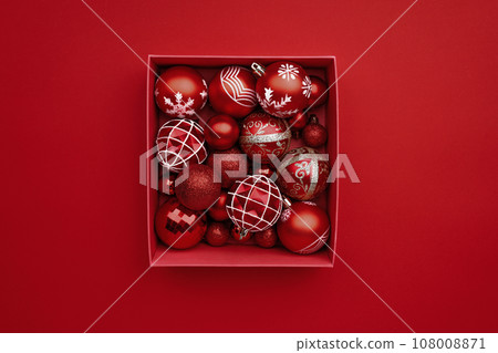 Red Christmas baubles decoration in the box on red background Red Christmas baubles decoration in the box on red background 108008871