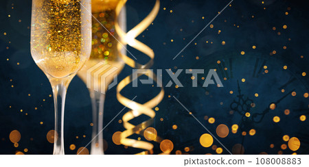 Two New Year's glasses of champagne with highlights on a colored background Two New Year's glasses of champagne with highlights on a colored background 108008883