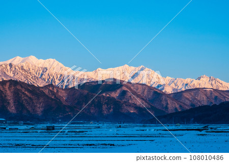 Mt. Jigatake, Mt. Kashimayarigatake, and Mt. Goryu in winter seen from Omachi City (dawn) 108010486