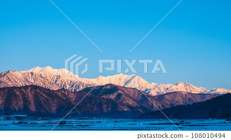 Mt. Jigatake, Mt. Kashimayarigatake, and Mt. Goryu in winter seen from Omachi City (dawn) 108010494