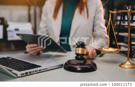 justice and law concept. asian woman lawyer working and judge in a courtroom the gavel, working with tablet and laptop and digital tablet computer 108011373