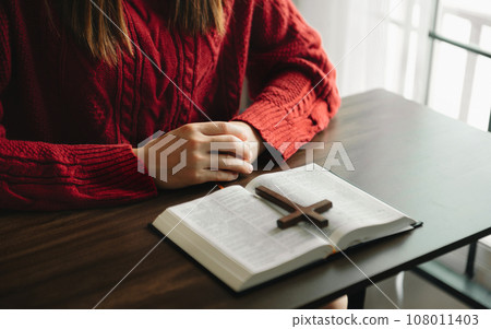 Woman praying on holy bible in the morning.Woman hand with Bible praying. Christian life crisis prayer to god... Woman praying on holy bible in the morning.Woman hand with Bible praying. Christian life crisis prayer to god... 108011403