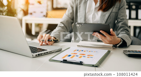 Businessman hand using smart phone laptop and tablet with social network diagram on desk as concept in morning light. 108011424