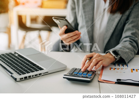 Businessman hand using smart phone laptop and tablet with social network diagram on desk as concept in morning light. 108011427