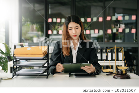 justice and law concept. asian woman lawyer working and judge in a courtroom the gavel, working with tablet and laptop and digital tablet computer 108011507