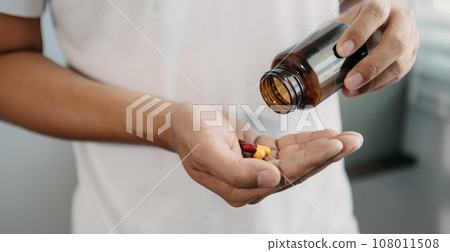 pills in a Senior's hands. Painful young age. Caring for the health of the elderly 108011508