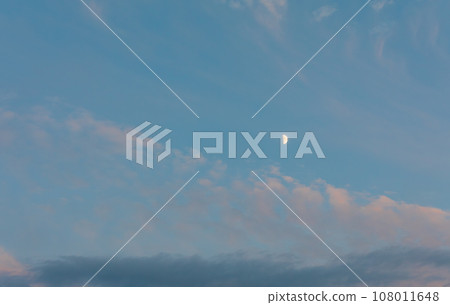 The moon floating in the sunset sky. 108011648