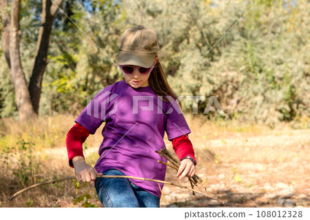 Child collects brushwood during hike 108012328