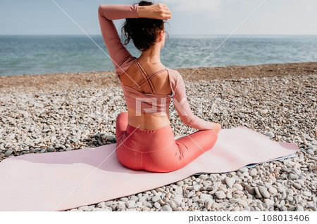 Woman sea pilates. Sporty happy middle aged woman practicing fitness on beach near sea, smiling active female training with ring on yoga mat outside, enjoying healthy lifestyle, harmony and meditation 108013406