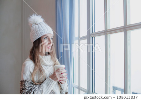 Attractive woman in casual winter clothes with hot drink indoor 108013837