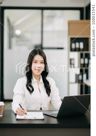 Successful Asian Businesswoman Analyzing Finance on Tablet and Laptop at Office Desk tax, report, accounting, statistics, and analytical research concept. Successful Asian Businesswoman Analyzing Finance on Tablet and Laptop at Office Desk tax, report, accounting, statistics, and analytical research concept. 108015541