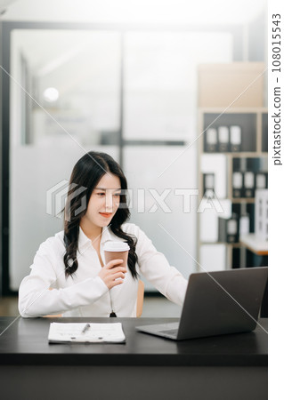 Successful Asian Businesswoman Analyzing Finance on Tablet and Laptop at Office Desk tax, report, accounting, statistics, and analytical research concept. Successful Asian Businesswoman Analyzing Finance on Tablet and Laptop at Office Desk tax, report, accounting, statistics, and analytical research concept. 108015543