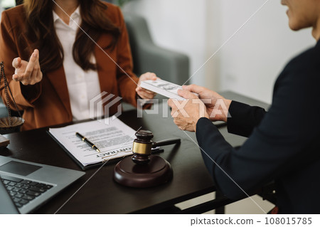 justice and law concept.passing bribe money in the envelop at office. businessman hand taking bribe money from female 108015785