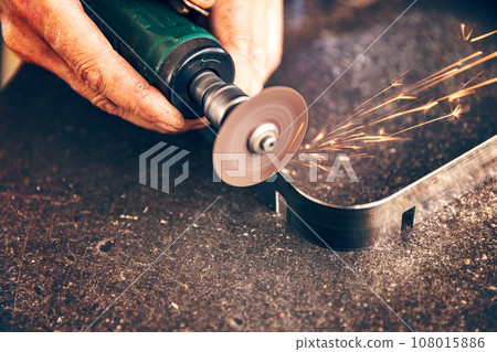 Worker cuts metal with metal sawing 108015886