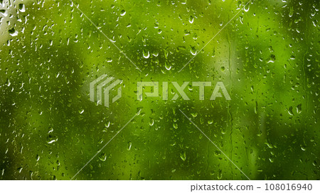 raindrops on a glass window against a background of green foliage, backgrounds, textures raindrops on a glass window against a background of green foliage, backgrounds, textures 108016940