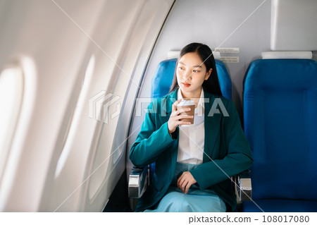 Asian woman sitting in a seat in airplane and looking out the window going on a trip vacation travel concept.Capture the allure of wanderlust 108017080